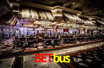 Una escena digital vívida inspirada en casino con Betbus mostrado prominentemente, luces brillantes, fichas, cartas y acentos dorados.